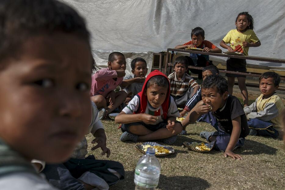 避難所で朝食を食べる子供たち=2015年5月5日（写真：ロイター/アフロ）