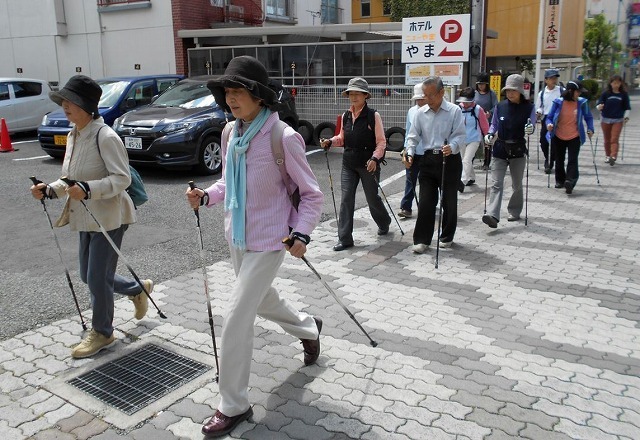 [写真]街を歩くノルディックウオーキング参加者