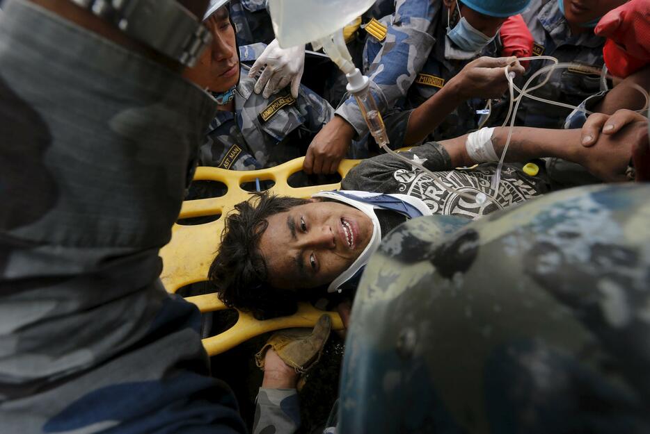 崩れたホテルの下から、120時間ぶりに救出された15歳少年＝2015年4月30日（写真：ロイター/アフロ）