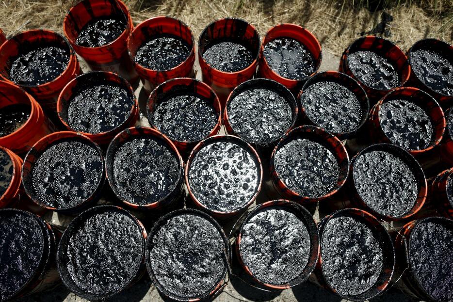 ボランティアが集めた原油のバケツが並ぶ＝2015年5月20日（写真：ロイター/アフロ）