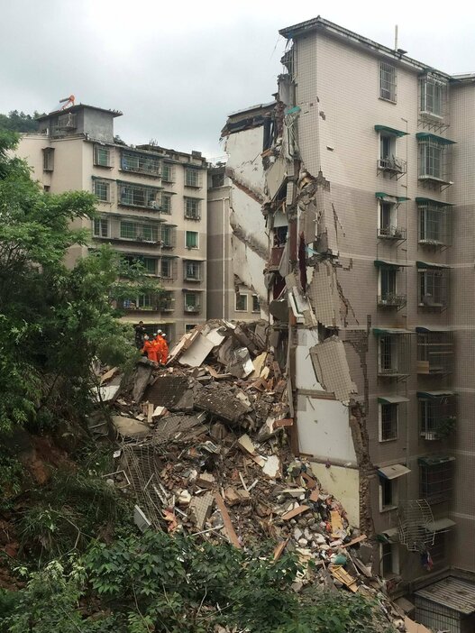 隣のマンションの半ばまで埋めたがれき＝2015年5月20日（写真：ロイター/アフロ）