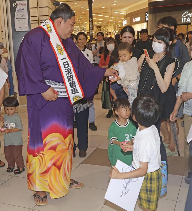 熱田消防署の一日署長に就任し、啓発グッズを配る関脇阿炎関＝1日午後、名古屋市熱田区