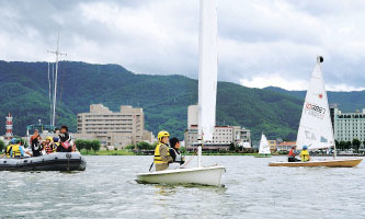 諏訪湖でヨットを体験する県内の子どもたち。ロス五輪に出場した山本悟さんの話も聞いた