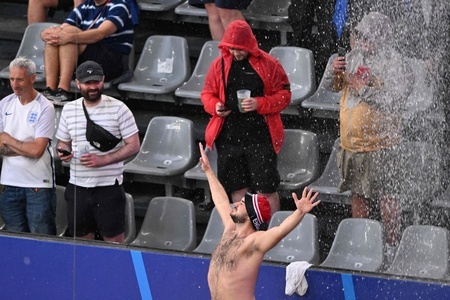 サッカー欧州選手権準決勝、オランダ対イングランド。試合開始を前に雨に打たれるイングランドのサポーター（2024年7月10日撮影）。