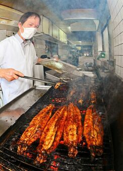 たれをつけながら、ウナギを焼き上げる店主の大橋正男さん＝佐賀市水ケ江の大橋うなぎ屋（魚眼レンズ使用、撮影・米倉義房）