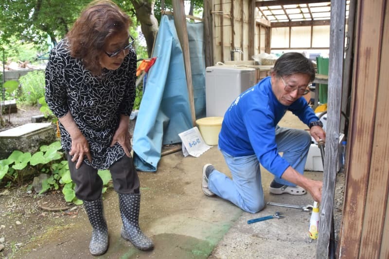 水道を修理する藤野さん（右）＝６月３日、石川県珠洲市