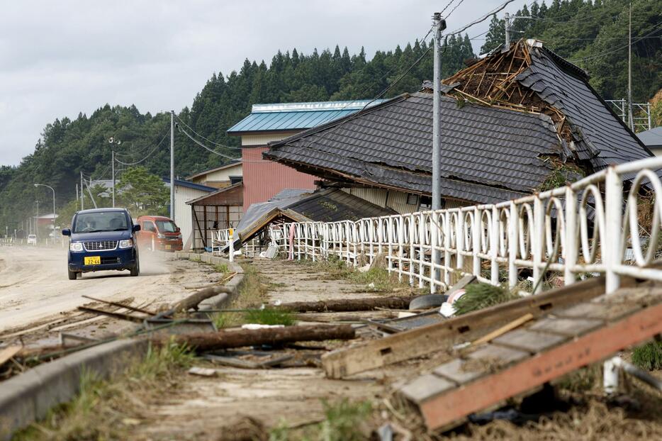 大雨の影響で崩れた家屋。裏山では土砂崩れが起きた＝27日午後2時45分、山形県鮭川村