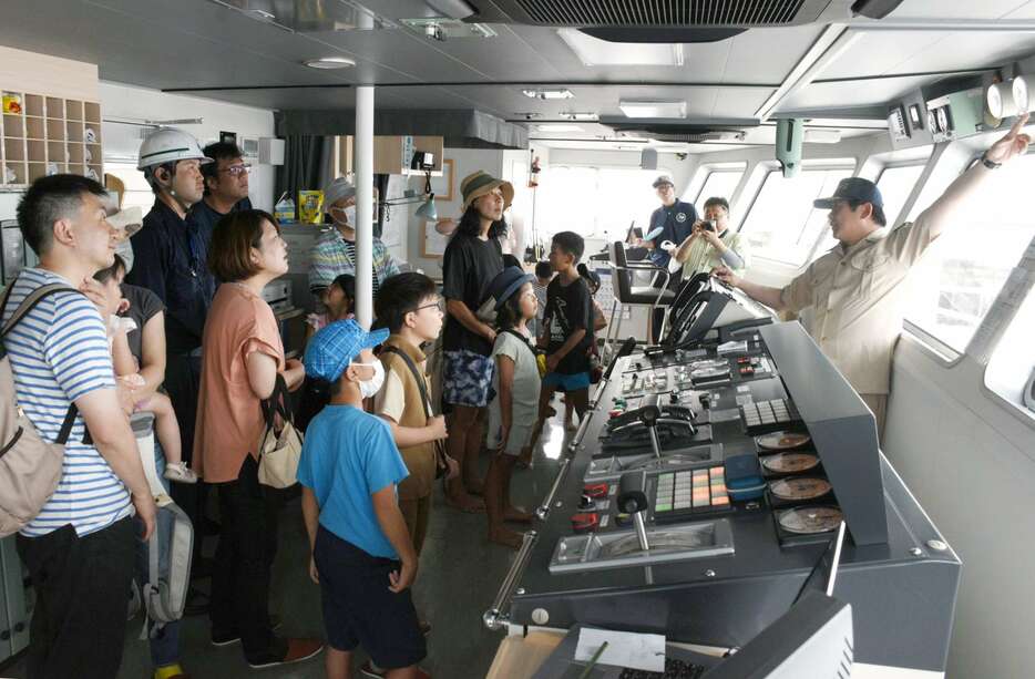 船長から船の仕組みを学ぶ親子連れ＝１５日、屋久島町の宮之浦港