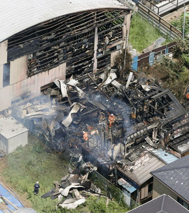 千葉県我孫子市の建物火災現場。隣接する市立湖北小の体育館（奥）に延焼した＝29日午後0時58分（共同通信社ヘリから）