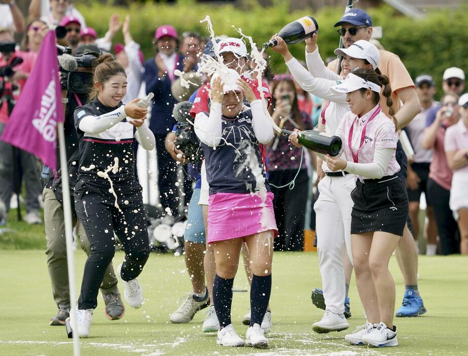 最終ラウンド、通算19アンダーで優勝し、山下美夢有（左端）らからシャンパンで祝福される古江彩佳（中央）＝14日、フランス南東部エビアンのエビアン・リゾートGC（共同）