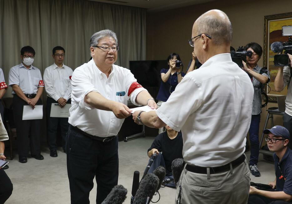 兵庫県の斎藤元彦知事の辞職を求める申し入れ書を片山安孝副知事（右）に手渡す県職員労働組合の土取節夫中央執行委員長＝10日午前、県庁