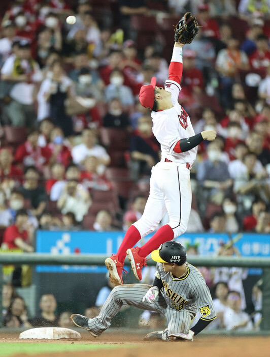延長１０回、島田の安打で三塁に進塁する阪神の一塁走者・小幡（下）。上は右翼手・野間の悪送球に手を伸ばす広島の三塁手・小園＝２日、マツダスタジアム