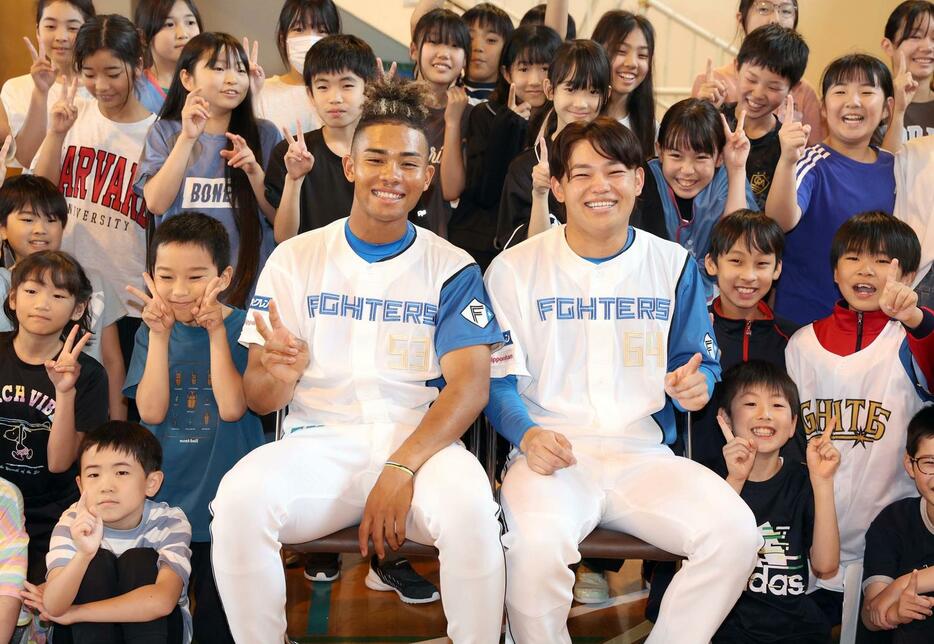 札幌市内の小学校を訪問した日本ハム田宮（左）と水谷は子どもたちと笑顔で記念撮影する（撮影・黒川智章）