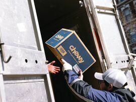 <p>A worker unloads a Chewy shipping box from a Fedex delivery vehicle in New York, US, on Friday, March 1, 2024. </p>