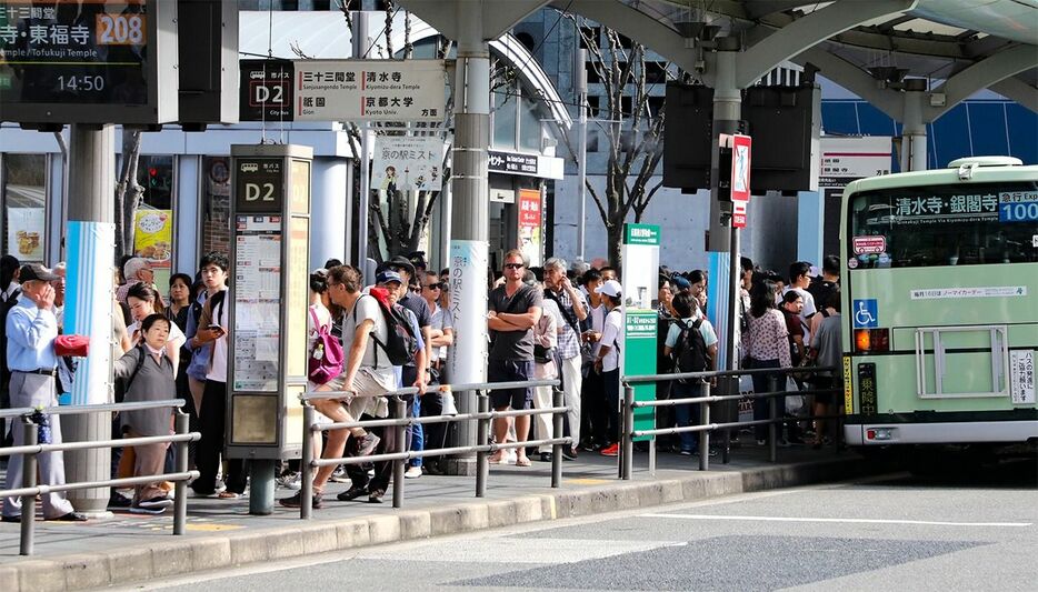 観光客らで混み合う京都駅前のバス乗り場＝京都市下京区（時事）