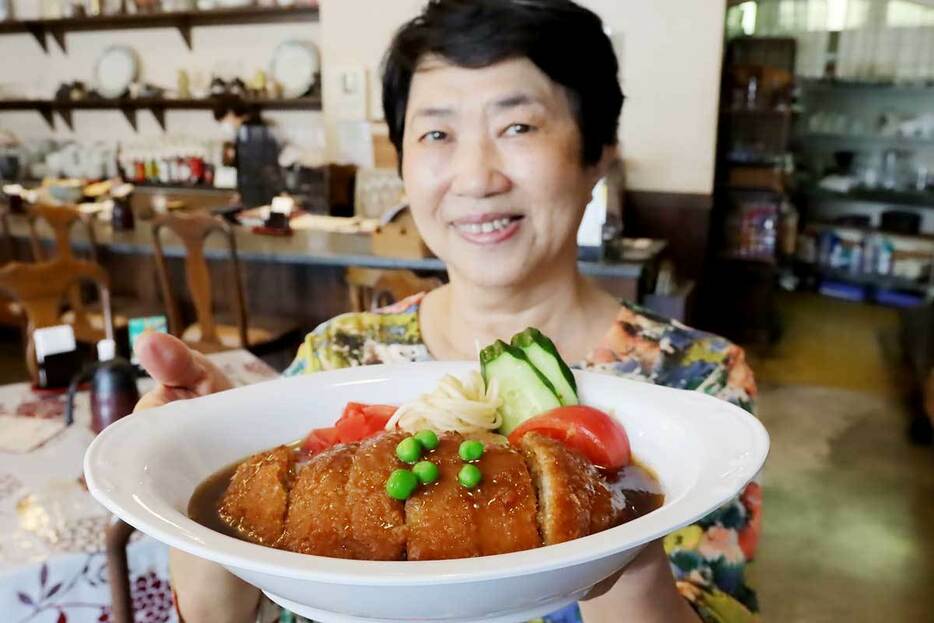 できたての洋風かつ丼を手にする松尾さん。当時はハイカラなごちそうだったという