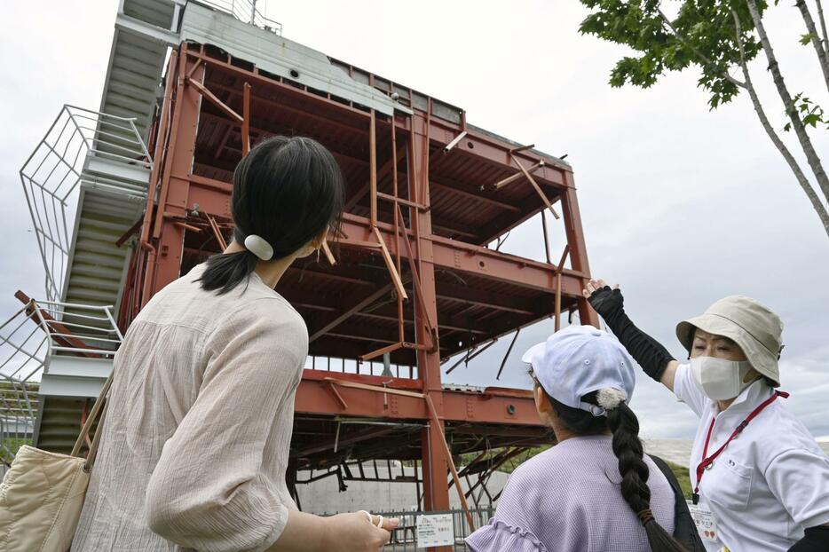 旧防災対策庁舎を案内する語り部の女性（右）＝1日、宮城県南三陸町