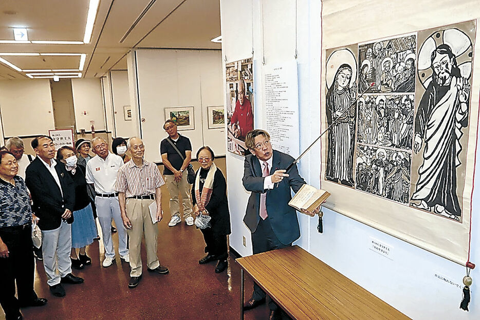 金守氏の作品を解説する高野さん＝富山市の県民会館