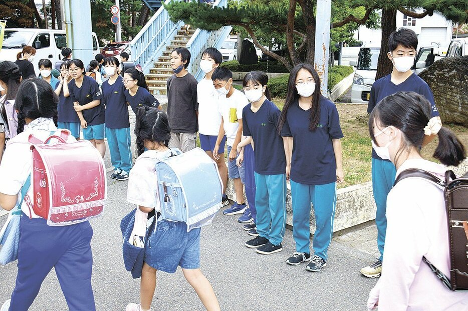 一緒に通学路に立ち、声掛けをする波田中生徒と波田小児童