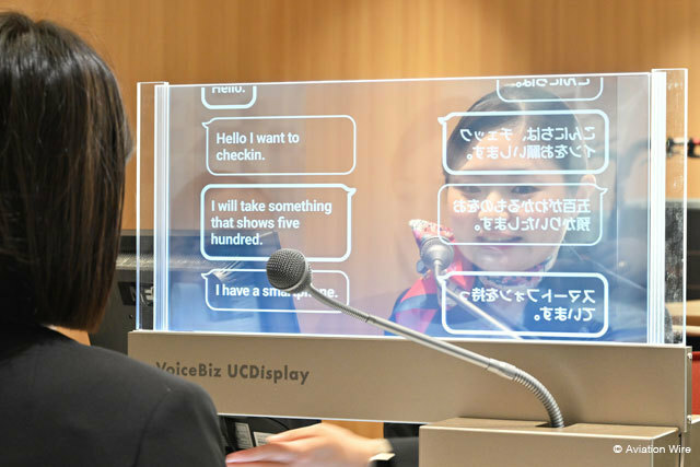 羽田空港で実施されたVoiceBiz UCDisplayの実証実験で英語を話す利用者役の社員（手前）と字幕でやり取りするJALのグランドスタッフ＝24年7月2日 PHOTO: Tadayuki YOSHIKAWA/Aviation Wire