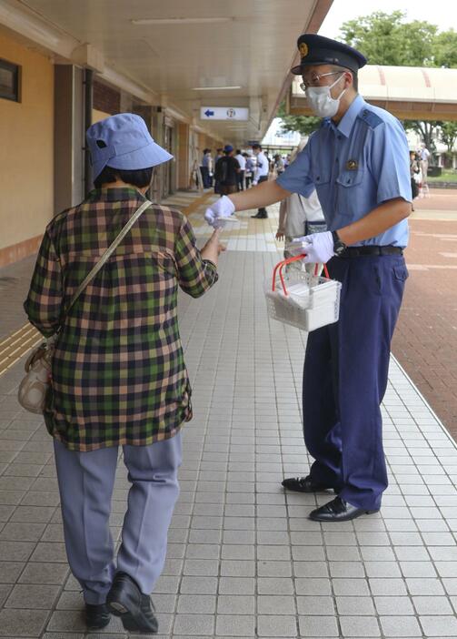 タクシー強殺事件から15年となり、JR鳥取駅前でビラの入ったティッシュを配る鳥取県警の捜査員＝17日午後