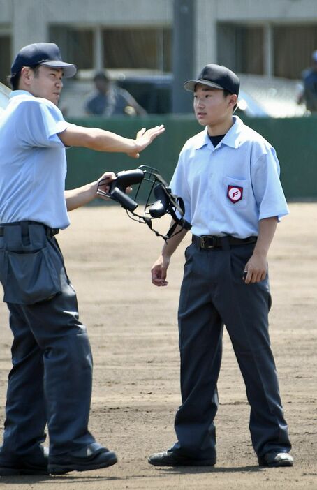 試合の合間に、審判の動きなどを東谷さん（左）から教わる加藤さん＝6月29日、青森市の青森山田高校グラウンド