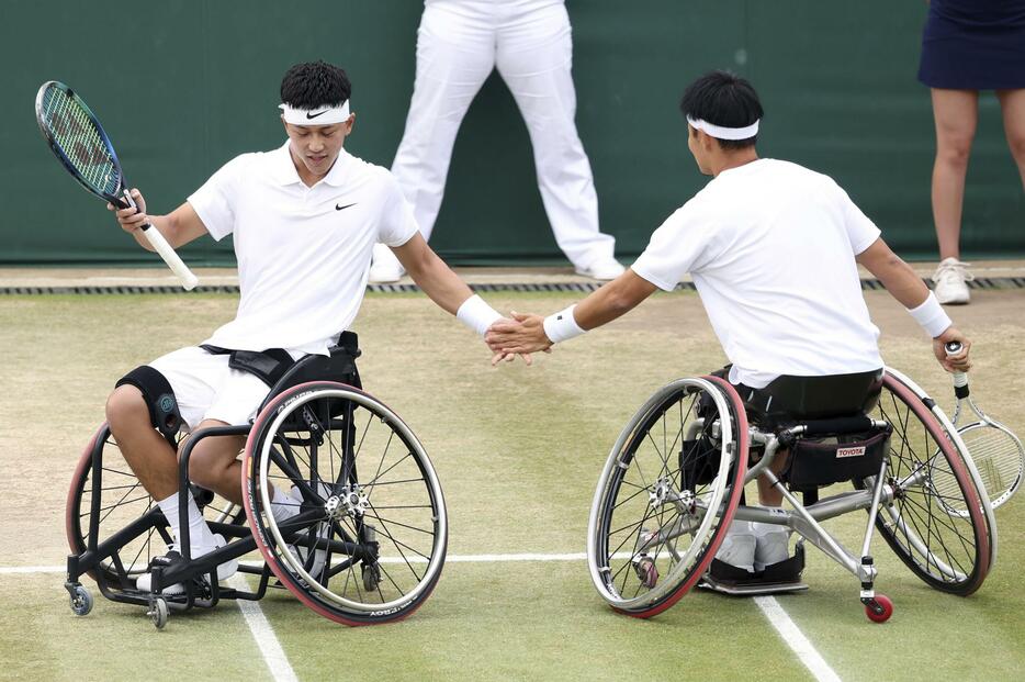 車いすの部男子ダブルス準決勝でポイントを奪い、タッチを交わす小田凱人（左）、三木拓也組＝ウィンブルドン（共同）