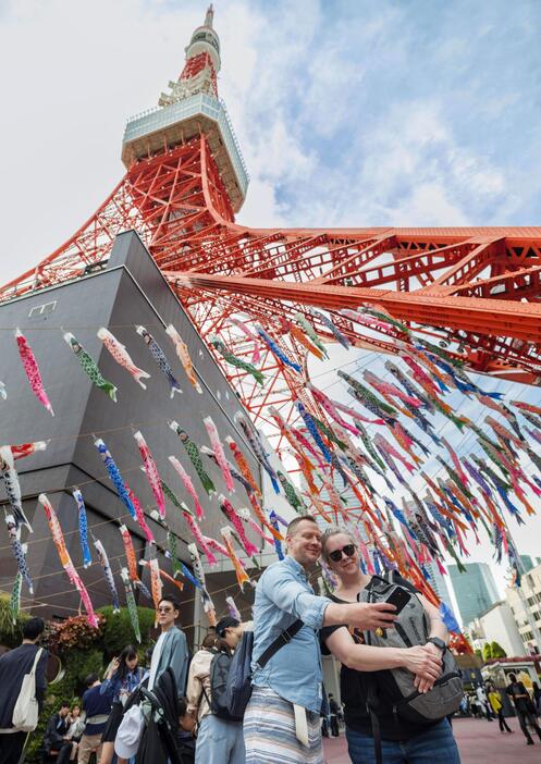 こいのぼりが舞う東京タワーを訪れた外国人観光客ら＝4月、東京都港区