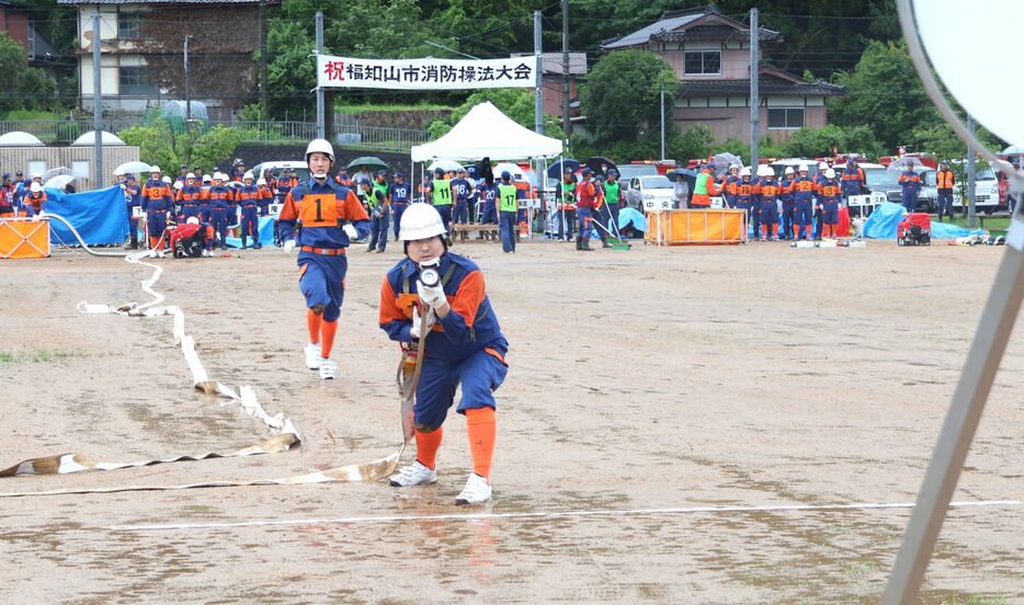 機敏な動きで火災への対応を披露する消防団員たち（京都府福知山市・大江河東公園多目的グラウンド）
