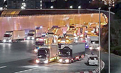 東名高速道路の東京料金所前で、深夜割引が適用される午前0時を待つため滞留するトラック＝2020年12月、川崎市（中日本高速道路提供）