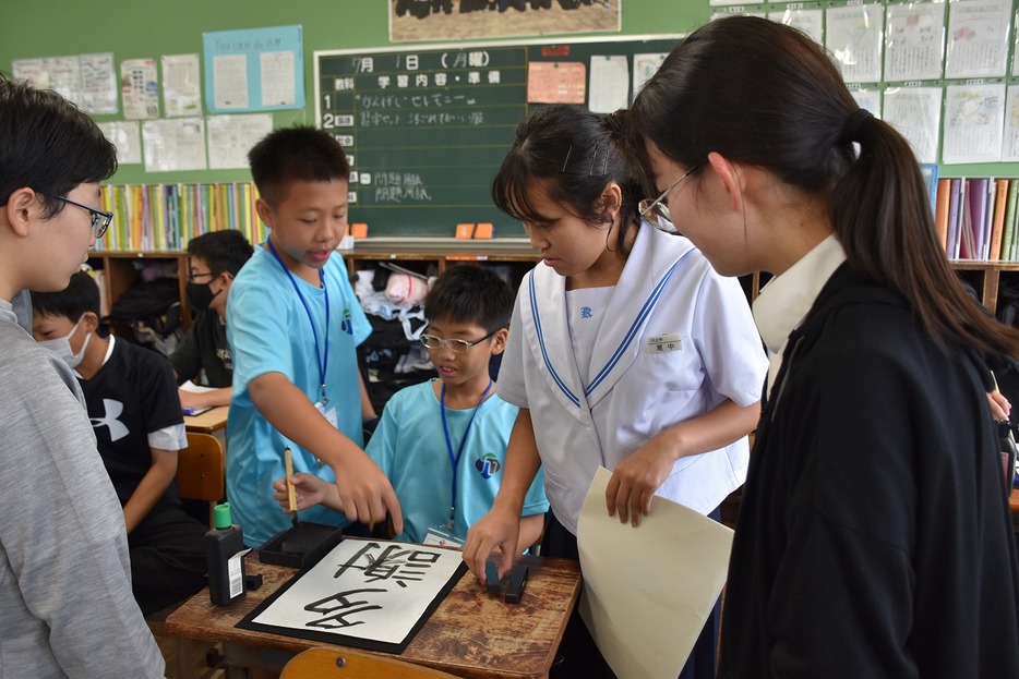 台湾の生徒に習字を教える川上中の生徒
