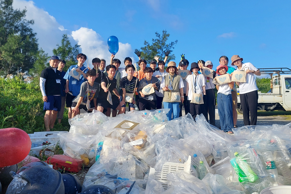 空港臨海公園前の海岸で清掃活動に励んだJAC環境保全ツアーの参加者ら＝6月30日、鹿児島県喜界町