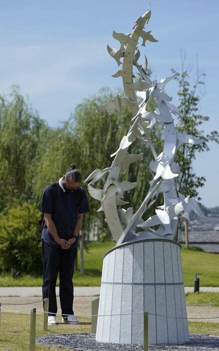 京都府宇治市の「志を☆（つな）ぐ碑」の前で犠牲者を悼む男性。京都アニメーション放火殺人事件から5年となった＝18日午前（注）☆は繋の車のタテ棒が山