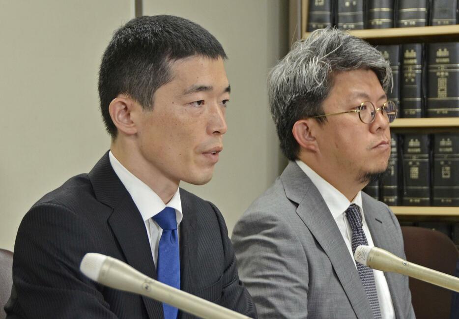 判決後、記者会見する江口大和氏（手前）＝18日午後、東京・霞が関の司法記者クラブ