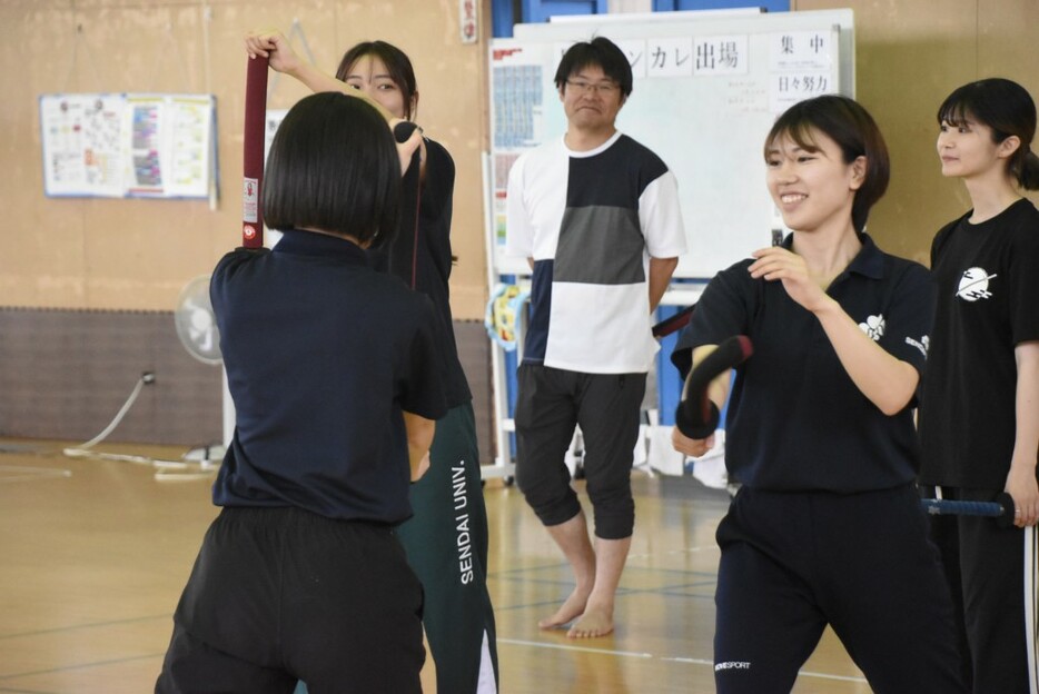 体験交流会で学生たちを見守る南條監督（中央）