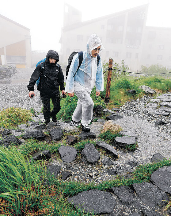 風雨の中を散策する観光客＝３０日午後０時半、立山・室堂