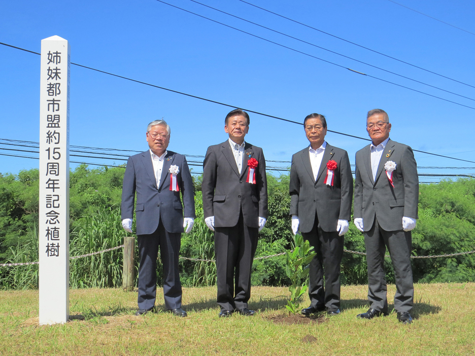 喜界町と伊佐市の親交の継続を誓った植樹祭。（左から）隈崎悦男町長、橋本欣也市長ら＝5日、鹿児島県喜界町役場公園