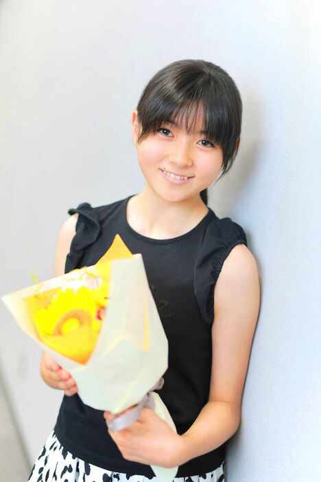 ７月２５日に迎える１３歳の誕生日を祝って贈られた花束を手に笑顔の堀越麗禾（カメラ・小泉　洋樹）