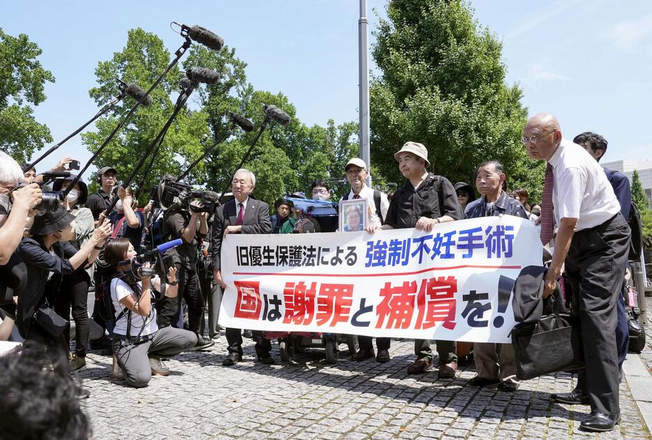 旧優生保護法違憲訴訟の上告審判決で、横断幕を手に最高裁に向かう原告と弁護団ら＝3日午後