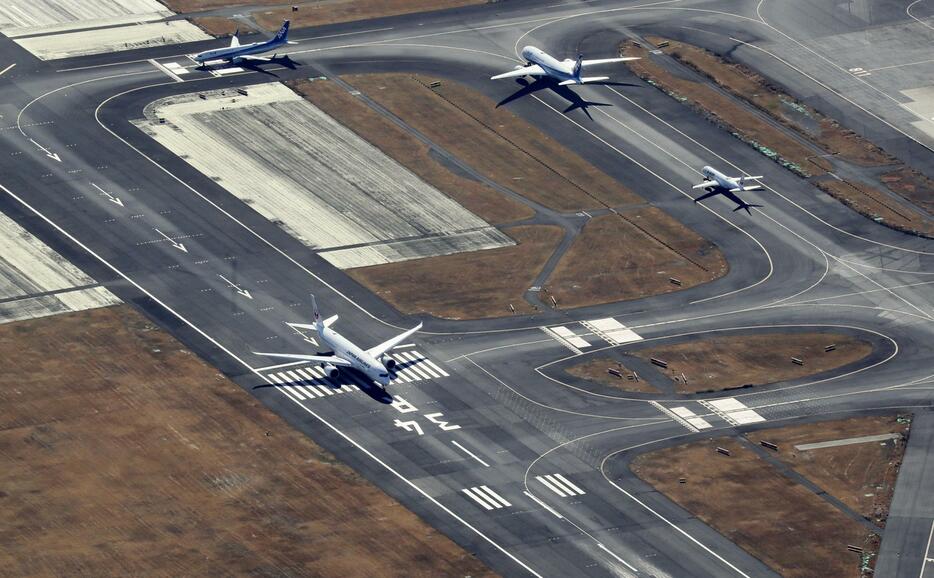 羽田空港のC滑走路（左）での離陸に向け待機する航空機＝1月