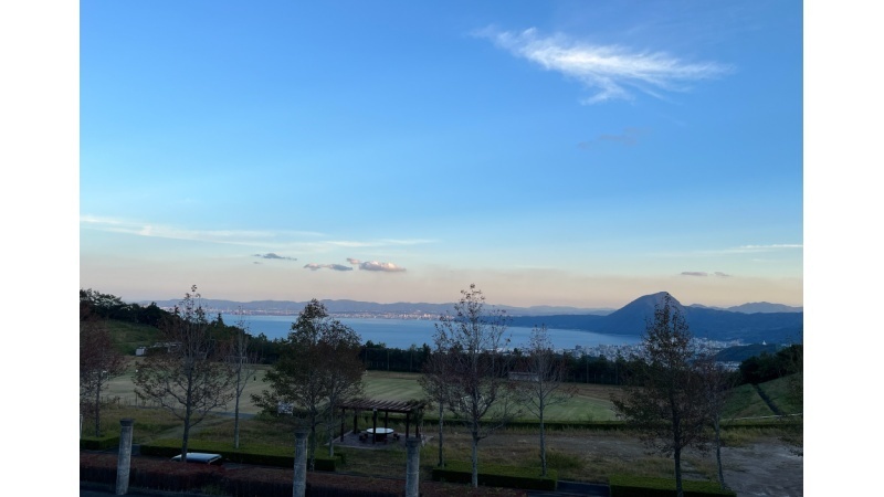 晴れた日に、キャンパスからグラウンド越しに見下ろす別府湾の風景