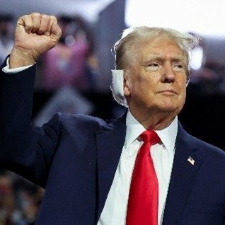 右耳をガーゼで覆い、右拳を掲げるトランプ前大統領（写真／共同通信社）