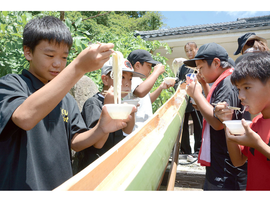 暑さの中で流しそうめんを楽しむ子どもたち＝27日、鹿児島県天城町当部