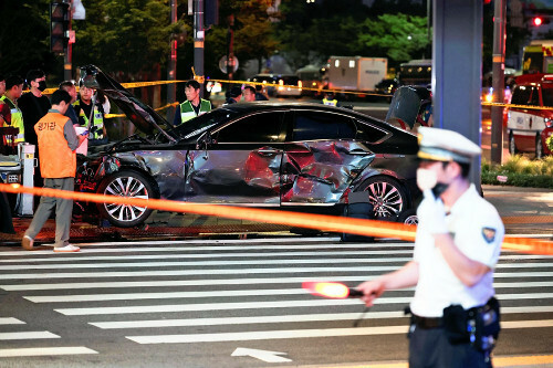 ソウルで事故に巻き込まれた車のそばに立つ警官（１日）＝ロイター