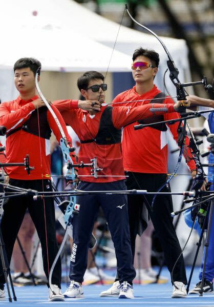 パリ五輪アーチェリーの男子ランキングラウンドで的を狙う中西絢哉（中央）＝７月２５日、パリ（共同）