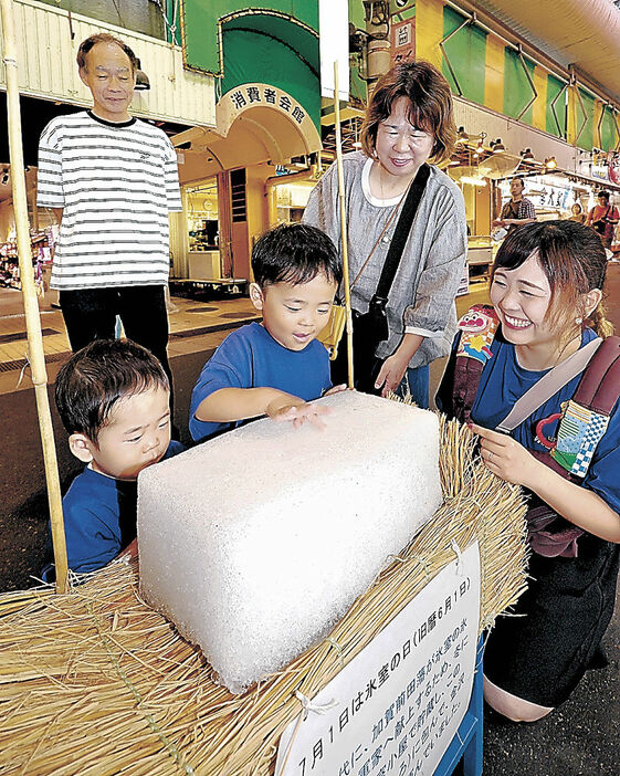 雪氷の感触を楽しむ親子連れ＝近江町市場