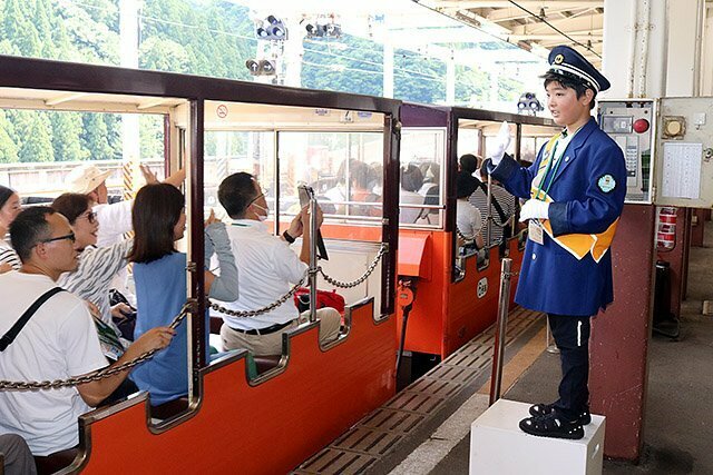 トロッコ電車の乗客を見送る小澤さん