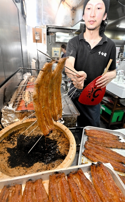 秘伝のたれに浸し、次々と焼かれるウナギ＝7月23日、福井県福井市毛矢1丁目のうな信