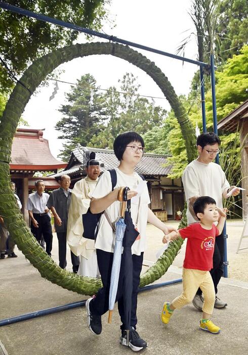 夏越の大祓で茅の輪をくぐる参拝者ら＝30日午後、伊達市・霊山神社