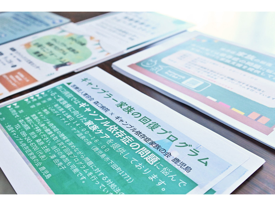 フォーラムの中継会場に置かれた資料。森口病院の田中大三院長は「ギャンブル依存症は、誰かとつながることで必ず回復する」と呼び掛けている＝6月22日、鹿児島県奄美市名瀬